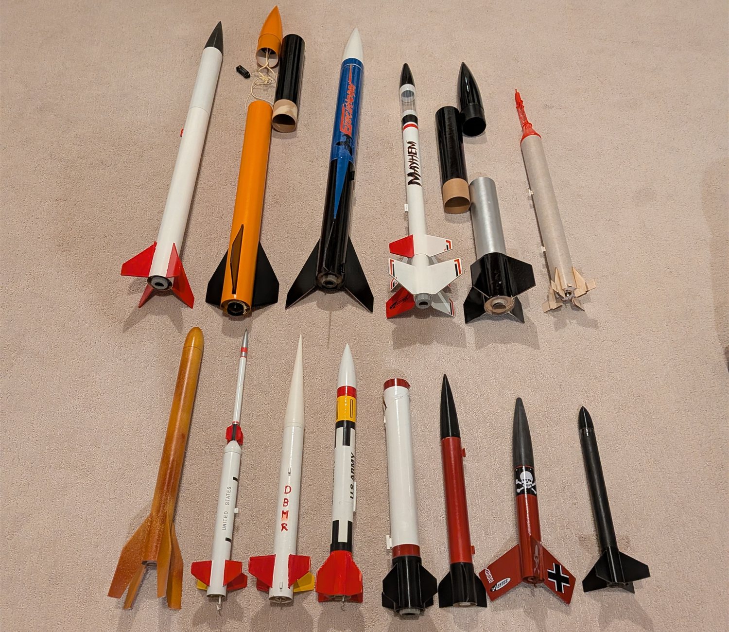 14 model rockets laid out in two rows